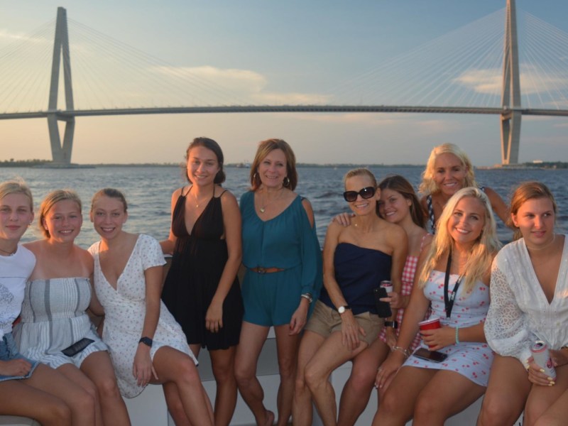 a group of people posing in front of a body of water