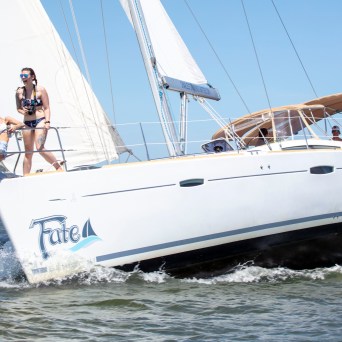 Two women enjoying a sunny day on a sailing yacht named Fate.
