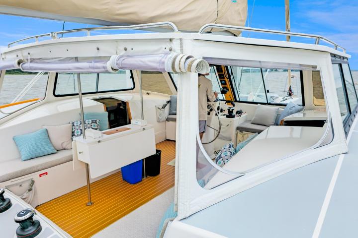 Interior view of a yacht cockpit with plush seating and a steering area.